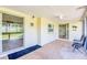 Screened patio with ceiling fan, indoor-outdoor carpet and sliding glass doors leading to the lush outdoor space at 2132 Sandpiper Dr, Clearwater, FL 33764