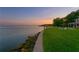 Lush backyard featuring an in-ground pool adjacent to open water, complemented by well-maintained landscaping at 218 Colony Point S Rd, St Petersburg, FL 33705