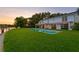 Lush green backyard featuring an in-ground pool with clear water and scenic water views at 218 Colony Point S Rd, St Petersburg, FL 33705