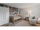 Cozy Bedroom with a wooden crib, a bookshelf filled with books, and a comfortable armchair at 218 Colony Point S Rd, St Petersburg, FL 33705