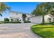 A bright and beautiful exterior view of this waterfront home with well manicured lawn, a circular driveway, and mature landscaping at 218 Colony Point S Rd, St Petersburg, FL 33705