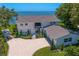 Beautiful two-story white home with manicured landscaping, a circular driveway, and stunning water views at 218 Colony Point S Rd, St Petersburg, FL 33705