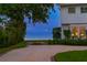 Well-manicured front yard with lush landscaping and a serene water view beyond at 218 Colony Point S Rd, St Petersburg, FL 33705