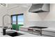 Modern kitchen with high-end stainless steel range and hood, white countertops, and views of the water at 218 Colony Point S Rd, St Petersburg, FL 33705