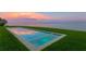Modern in-ground pool with crystal-clear water and submerged seating, set against a tranquil waterfront at 218 Colony Point S Rd, St Petersburg, FL 33705