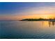 Scenic waterfront view featuring a serene bay at sunset, complete with lush trees and docks along the shoreline at 218 Colony Point S Rd, St Petersburg, FL 33705