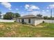 Back yard showing a well-maintained lawn, an exterior building wall, and a white fence at 27050 Anthony Ave, Brooksville, FL 34602