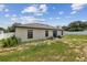Back yard showing a well-maintained lawn, an exterior building wall, and a white fence at 27050 Anthony Ave, Brooksville, FL 34602