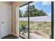 Backyard view from interior featuring glass sliding door, white fence, and a small patio at 27050 Anthony Ave, Brooksville, FL 34602