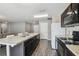 Kitchen featuring a breakfast bar, dark cabinetry, modern appliances, and wood-look laminate flooring at 27050 Anthony Ave, Brooksville, FL 34602