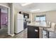 Kitchen featuring dark cabinetry, breakfast bar seating, and modern appliances in a neutral color scheme at 27050 Anthony Ave, Brooksville, FL 34602