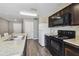 Bright kitchen features dark cabinetry, a breakfast bar, and modern appliances in a neutral color scheme at 27050 Anthony Ave, Brooksville, FL 34602
