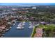 Expansive aerial view showcasing a marina filled with boats, surrounded by lush greenery, a golf course and residential buildings at 2773 Seabreeze S Dr, Gulfport, FL 33707