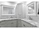 Bright bathroom featuring double sinks, large mirrors, cabinets, and marble countertops at 2773 Seabreeze S Dr, Gulfport, FL 33707