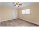 Cozy bedroom with wood-look flooring, a ceiling fan, and a window offering natural light at 2773 Seabreeze S Dr, Gulfport, FL 33707