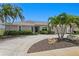 Charming single-story home with lush landscaping, circular driveway, and mature palm trees, a true Florida paradise at 2773 Seabreeze S Dr, Gulfport, FL 33707