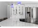 Bright kitchen featuring modern stainless-steel appliances, marble countertops, and decorative hanging light fixtures at 2773 Seabreeze S Dr, Gulfport, FL 33707