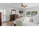 Main bedroom with water views, a dresser, a ceiling fan, and access to an outdoor seating area with a pool at 2773 Seabreeze S Dr, Gulfport, FL 33707