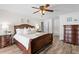 Spacious main bedroom features wood-look floors, updated ceiling fan, and a comfortable king-size bed at 2773 Seabreeze S Dr, Gulfport, FL 33707