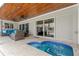 Cozy outdoor spa area features a wood-paneled ceiling, comfortable seating and access to the backyard at 2773 Seabreeze S Dr, Gulfport, FL 33707