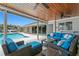 Outdoor patio with comfortable seating, outdoor ceiling fans, and a view of the pool and waterfront at 2773 Seabreeze S Dr, Gulfport, FL 33707