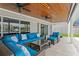 Covered patio featuring a blue seating set, glass table and two ceiling fans at 2773 Seabreeze S Dr, Gulfport, FL 33707