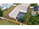 Aerial view of the home, showcasing the backyard, screened-in patio, and fenced perimeter at 2807 Northcote Dr, Palm Harbor, FL 34684