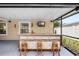 Covered patio bar with seating, a TV, and decorative accents for entertaining at 2807 Northcote Dr, Palm Harbor, FL 34684
