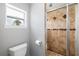 Bathroom featuring a shower with decorative tile and a toilet beneath a window with natural light at 2807 Northcote Dr, Palm Harbor, FL 34684