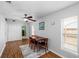 Bright dining area featuring hardwood floors, a ceiling fan, a modern table, and window with natural light at 2807 Northcote Dr, Palm Harbor, FL 34684