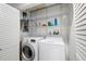 Convenient laundry room with washer, dryer, storage shelves, and electrical panel at 2807 Northcote Dr, Palm Harbor, FL 34684