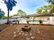 Landscaped backyard featuring an in-ground pool, fire pit, gazebo, and white vinyl fencing at 3143 Phoenix Ave, Oldsmar, FL 34677