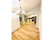 Open-concept dining room boasts wood floors, modern light fixture and adjacent kitchen views at 3143 Phoenix Ave, Oldsmar, FL 34677