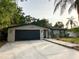 Inviting single-story home with a black garage door, manicured lawn, and brick walkway at 3143 Phoenix Ave, Oldsmar, FL 34677