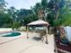 Relaxing gazebo with lounge chairs overlooking the pool and surrounding lush landscaping at 3143 Phoenix Ave, Oldsmar, FL 34677