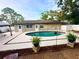 Backyard view of in-ground pool with lush landscaping and ample patio space at 3143 Phoenix Ave, Oldsmar, FL 34677