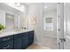 Charming bathroom with a decorative mirror, modern vanity, and a glimpse into a well-lit bedroom at 33750 Ocean Spray Ln, Wesley Chapel, FL 33543