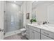 Stylish bathroom featuring a glass-enclosed shower, gray vanity, and modern fixtures at 33750 Ocean Spray Ln, Wesley Chapel, FL 33543