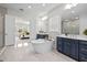 Spa-like bathroom with a freestanding tub, walk-in shower, and blue cabinets at 33750 Ocean Spray Ln, Wesley Chapel, FL 33543