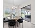 Bright dining room with a modern chandelier, a wood table, and a view of the backyard through sliding glass doors at 33750 Ocean Spray Ln, Wesley Chapel, FL 33543