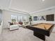 Well-lit game room with a pool table, comfortable seating, and stylish decor at 33750 Ocean Spray Ln, Wesley Chapel, FL 33543