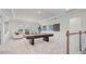 Bright game room with a pool table, white carpeting, and a comfortable seating area at 33750 Ocean Spray Ln, Wesley Chapel, FL 33543