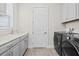 Well-lit laundry room with modern washer and dryer, complemented by stylish countertops and cabinets at 33750 Ocean Spray Ln, Wesley Chapel, FL 33543