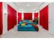 Inviting home theater room with a comfortable blue sofa and dramatic red curtains at 33750 Ocean Spray Ln, Wesley Chapel, FL 33543