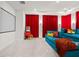 Cozy home theater with a blue sectional sofa, red curtains, and a popcorn machine at 33750 Ocean Spray Ln, Wesley Chapel, FL 33543