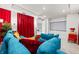 Well-equipped home theater with a large blue sofa, red drapes, and a projector screen at 33750 Ocean Spray Ln, Wesley Chapel, FL 33543