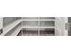 Organized walk-in pantry with custom shelving and wood-look tile floors offers ample storage space at 33750 Ocean Spray Ln, Wesley Chapel, FL 33543