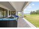 Expansive covered patio with stone flooring offers serene views of the lake and surrounding greenery at 33750 Ocean Spray Ln, Wesley Chapel, FL 33543