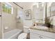 Bathroom featuring a shower-tub combo, granite counters, and updated vanity at 3702 W Cass St # 5, Tampa, FL 33609