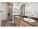 Bathroom featuring double sinks with granite countertops and a glass-enclosed shower at 3702 W Cass St # 5, Tampa, FL 33609